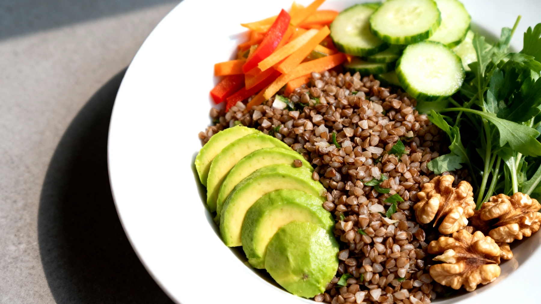Insalata di grano saraceno con avocado, noci e verdure crude"